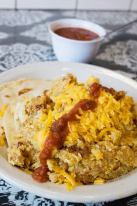 A plate of Don Juan El Taco Grande from Juan in a Million in Austin with a side of salsa in the background