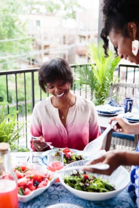 Jocelyn and her mom smiling at their weekly brunch outdoors