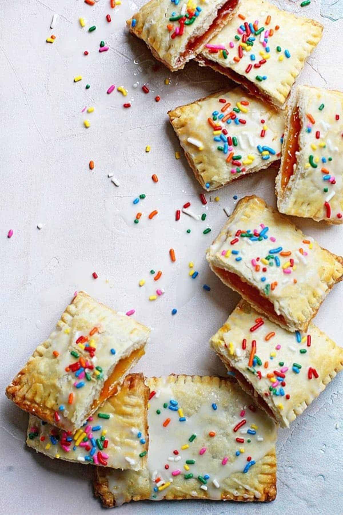 Homemade pop tarts with icing and sprinkles on the table at different angles.