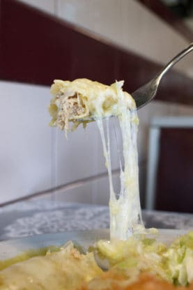 A photo of cheese being pulled from a Chicken Enchiladas from Juan in a Million