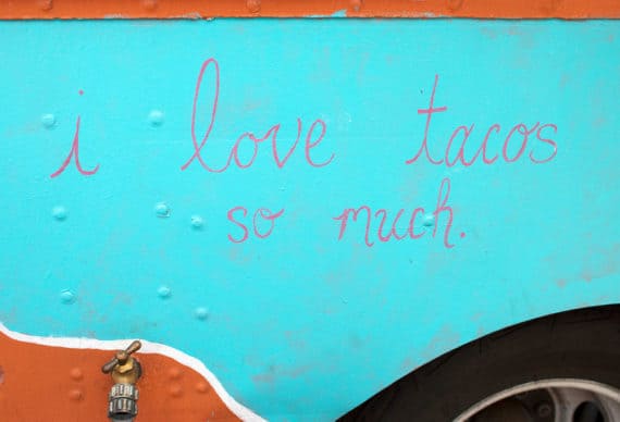 Photo of the words, "I love tacos so much." in cursive writing on the side of a food truck in Austin, TX