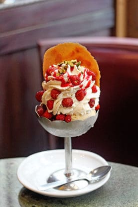 Rich and delicious ice cream topped strawberries and pistachios served at Berthillon in Paris
