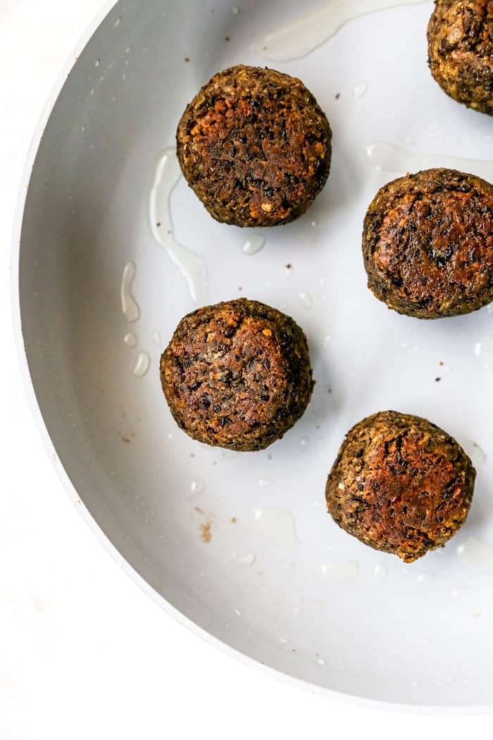 Lentil meatballs being cooked in a pan