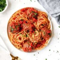 A white plate filled with vegetarian spaghetti and meatballs ready to serve