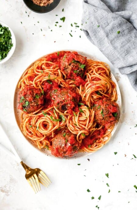 A white plate filled with vegetarian spaghetti and meatballs ready to serve