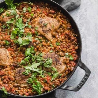 Spanish Chicken and Rice in a cast iron skillet on gray background