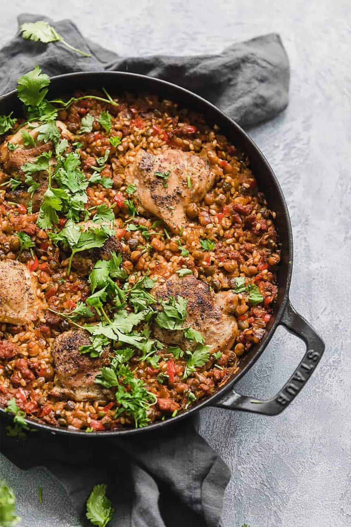 Spanish chicken and rice in a dutch oven garnished with cilantro.