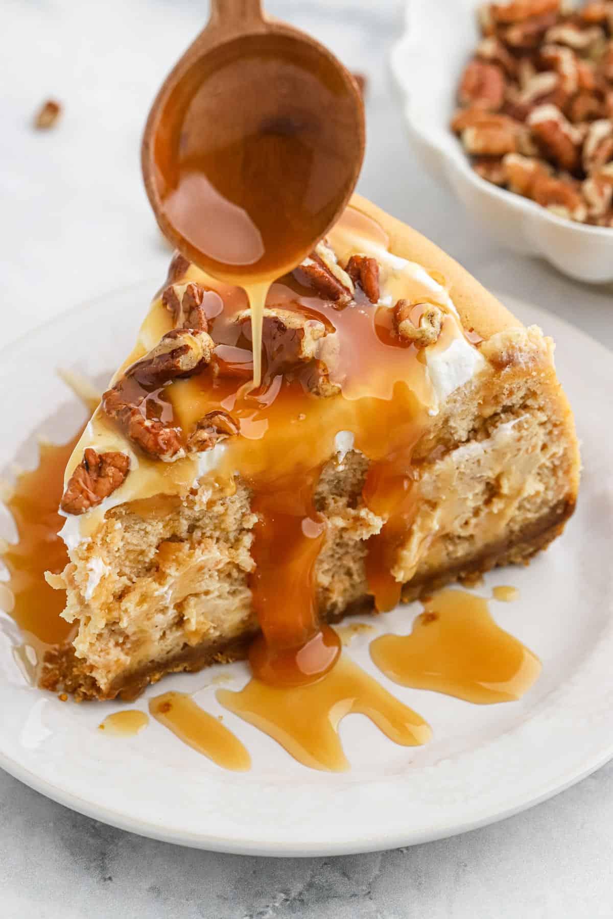 Caramel pouring over Sweet Potato cheesecake recipe with a spoon.