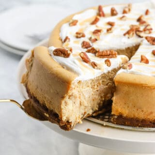 Spiced Sweet Potato Cheesecake Recipe on a white stand with slice being slid out