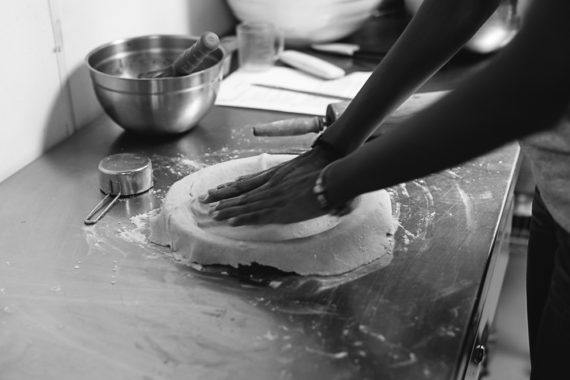 A student patting down her pie crust in a black and white photo