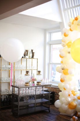 Two punch bowls, more glassware and a large set of white and gold balloons