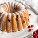 Cranberry Orange Pound Cake on a white platter on white background