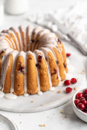 Cranberry Orange Pound Cake being held sitting on a white plate. 