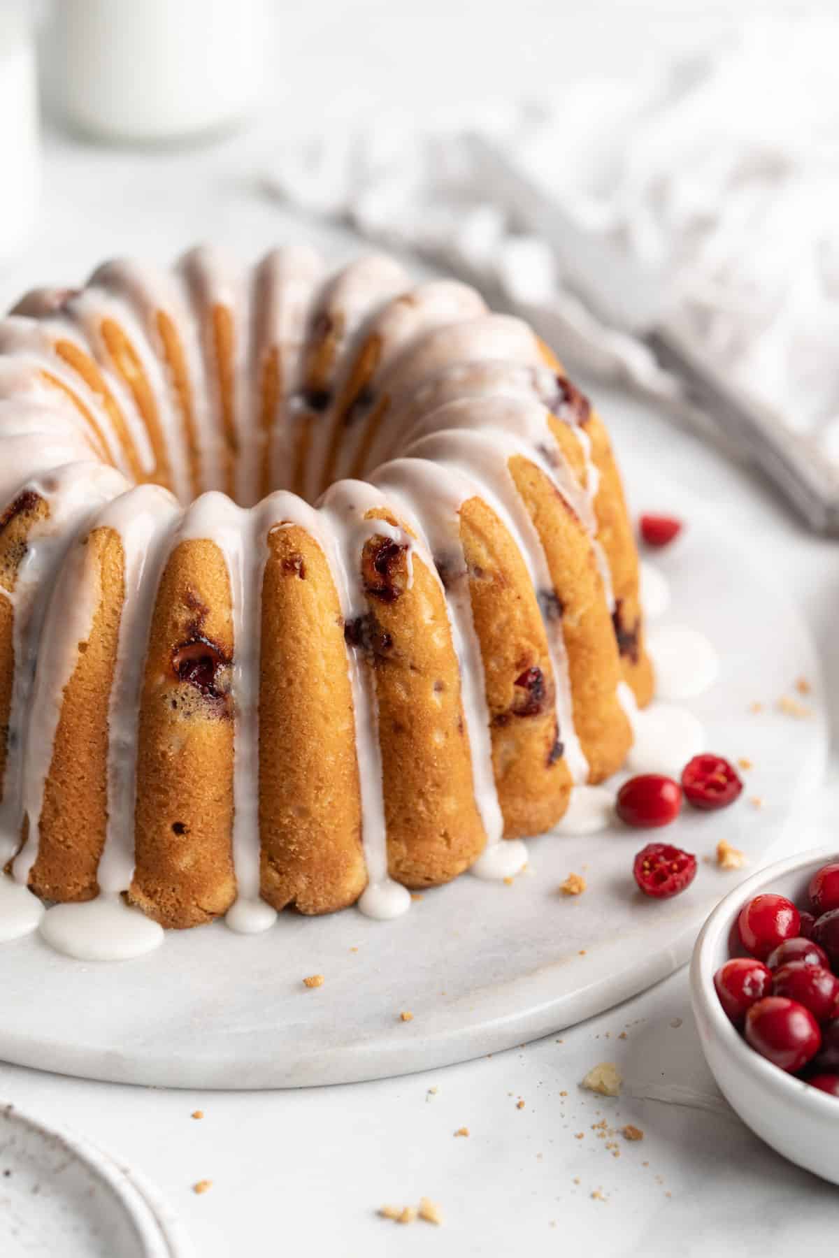 Cranberry Orange Pound Cake on a white platter on white background