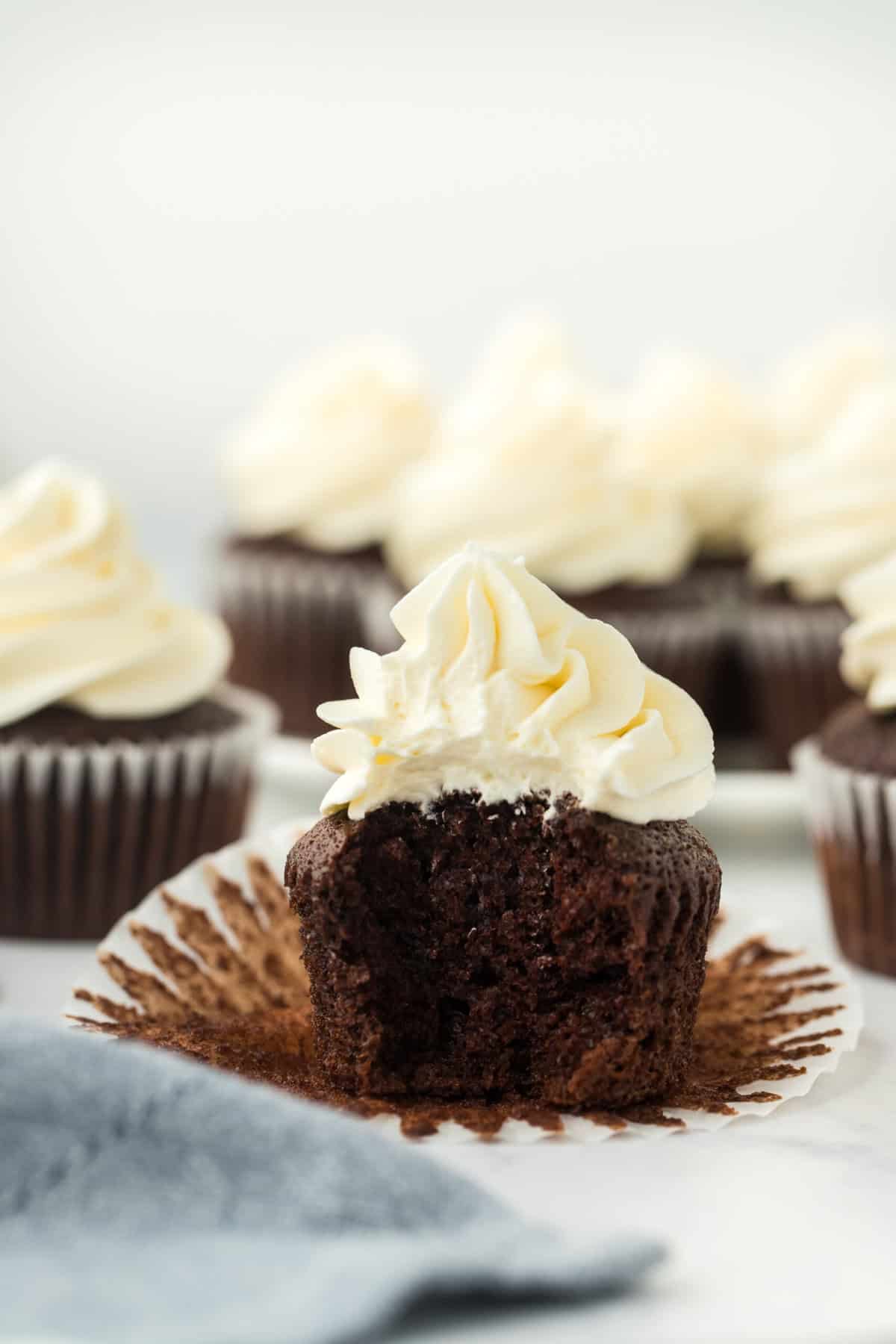 The best chocolate cupcake with a large bite removed and cupcakes in the white background