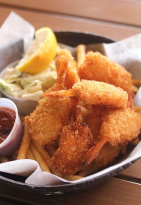 Delicious fried coconut shrimp on top of a bed of fries from Coconut’s Fish Cafe