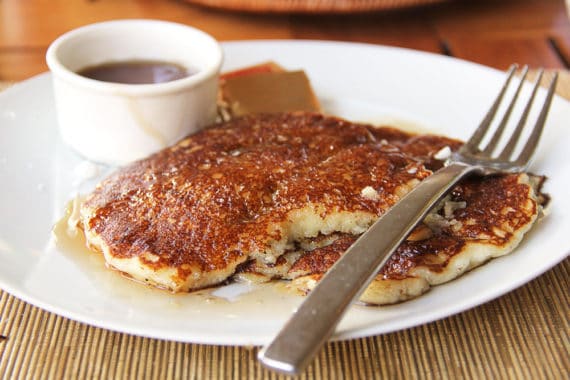 Pancakes and syrup on a white plate with a fork from the buffet at the Four Seasons Resort