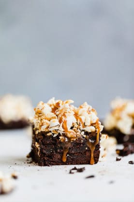 Close up of a Salted Caramel Popcorn Brownie with more brownies in the background and out of focus