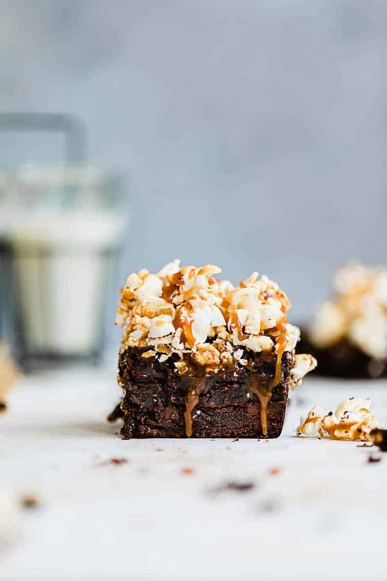 Close up of a Salted Caramel Popcorn Brownie with more brownies in the background and out of focus