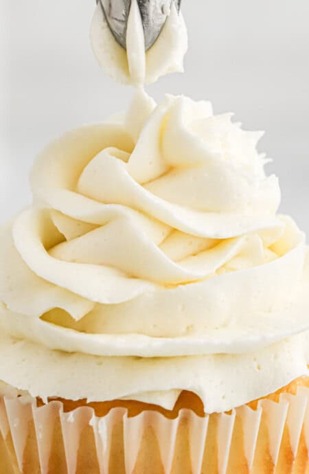 Topping a cupcake with American buttercream frosting.