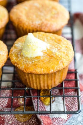 A close up of Corn Muffins on wire rack with melted butter