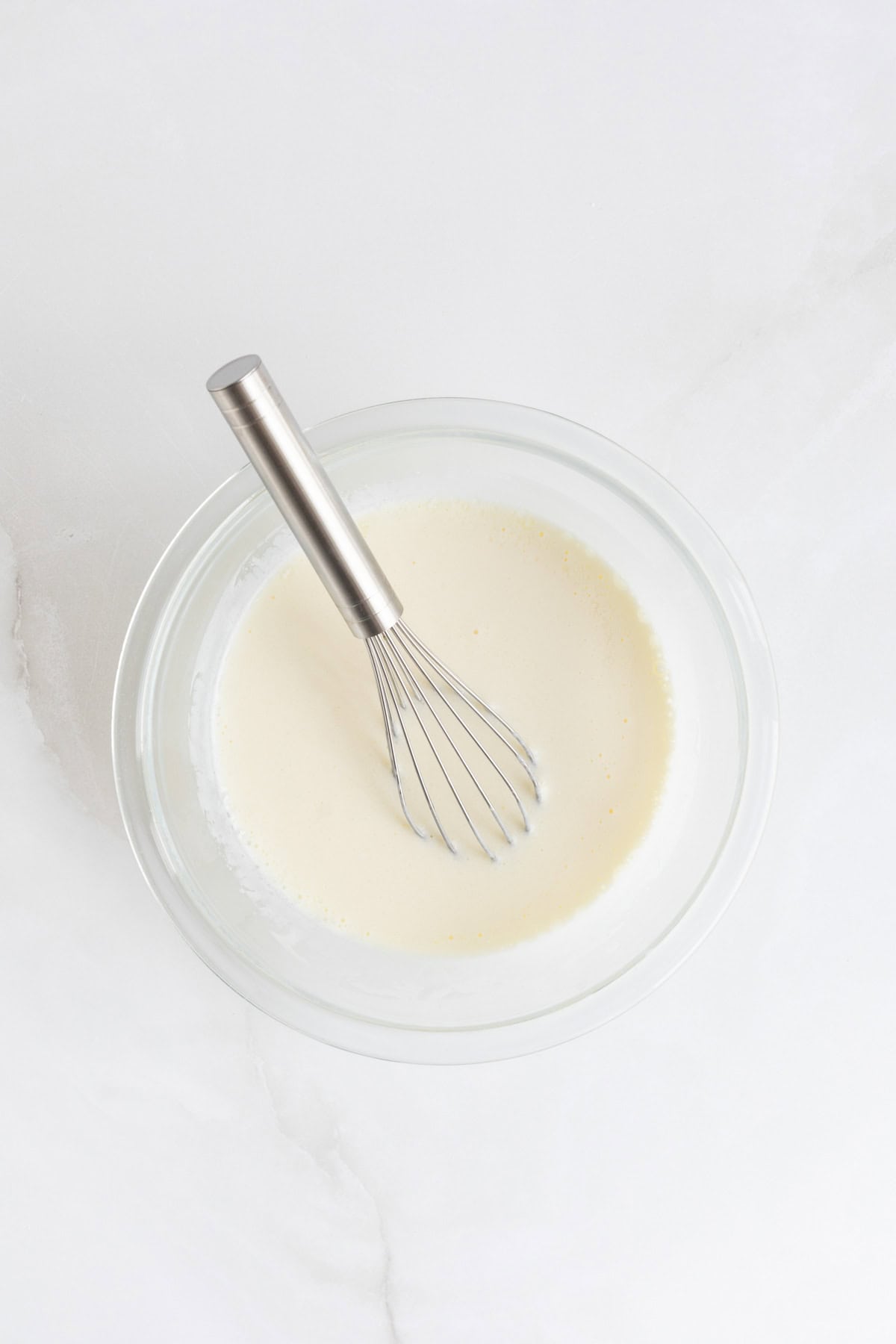 Wet ingredients in a separate bowl fully whisked into a smooth mixture with a metal whisk