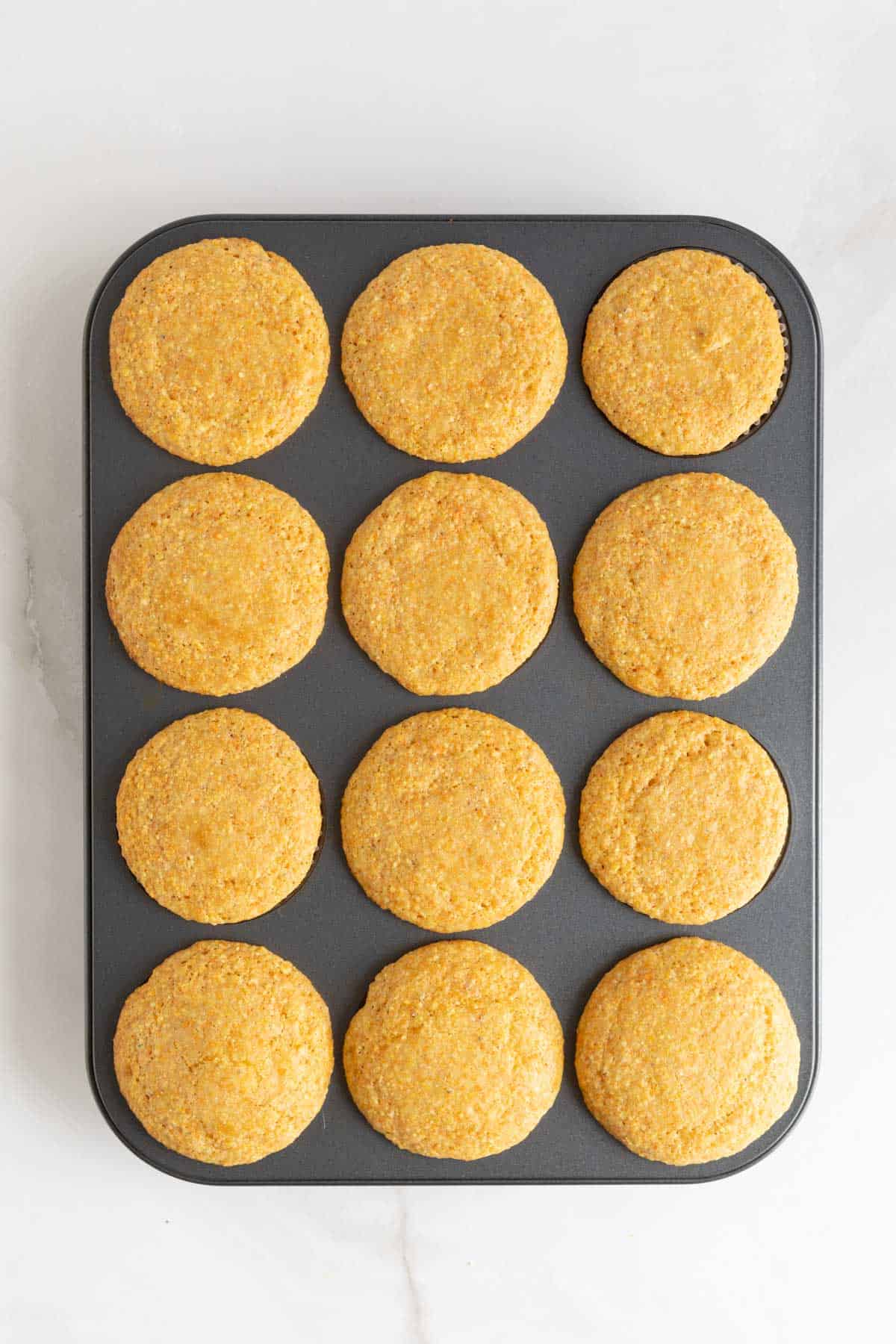 Golden brown cornbread muffins fresh out of the oven in the pan