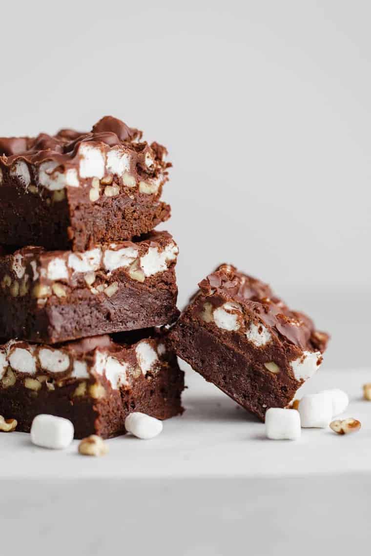 Mississippi Mud Brownies stacked on each other with marshmallows and nuts next to them