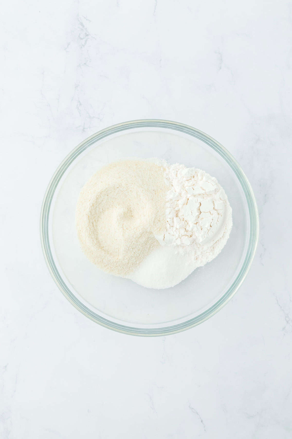 Dry ingredients in a glass bowl on a white countertop