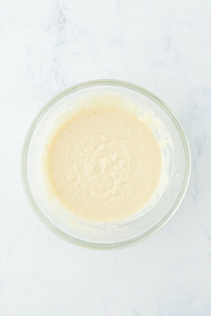 Smooth hoe cake recipe batter in glass bowl on white countertop