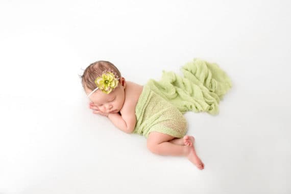 Sleeping Harmony wrapped up in a green blanket and wearing a green flower in her hair