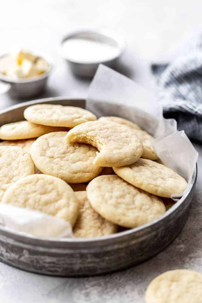 Close up of bitten into Southern Tea Cake on top of several cookies in tin