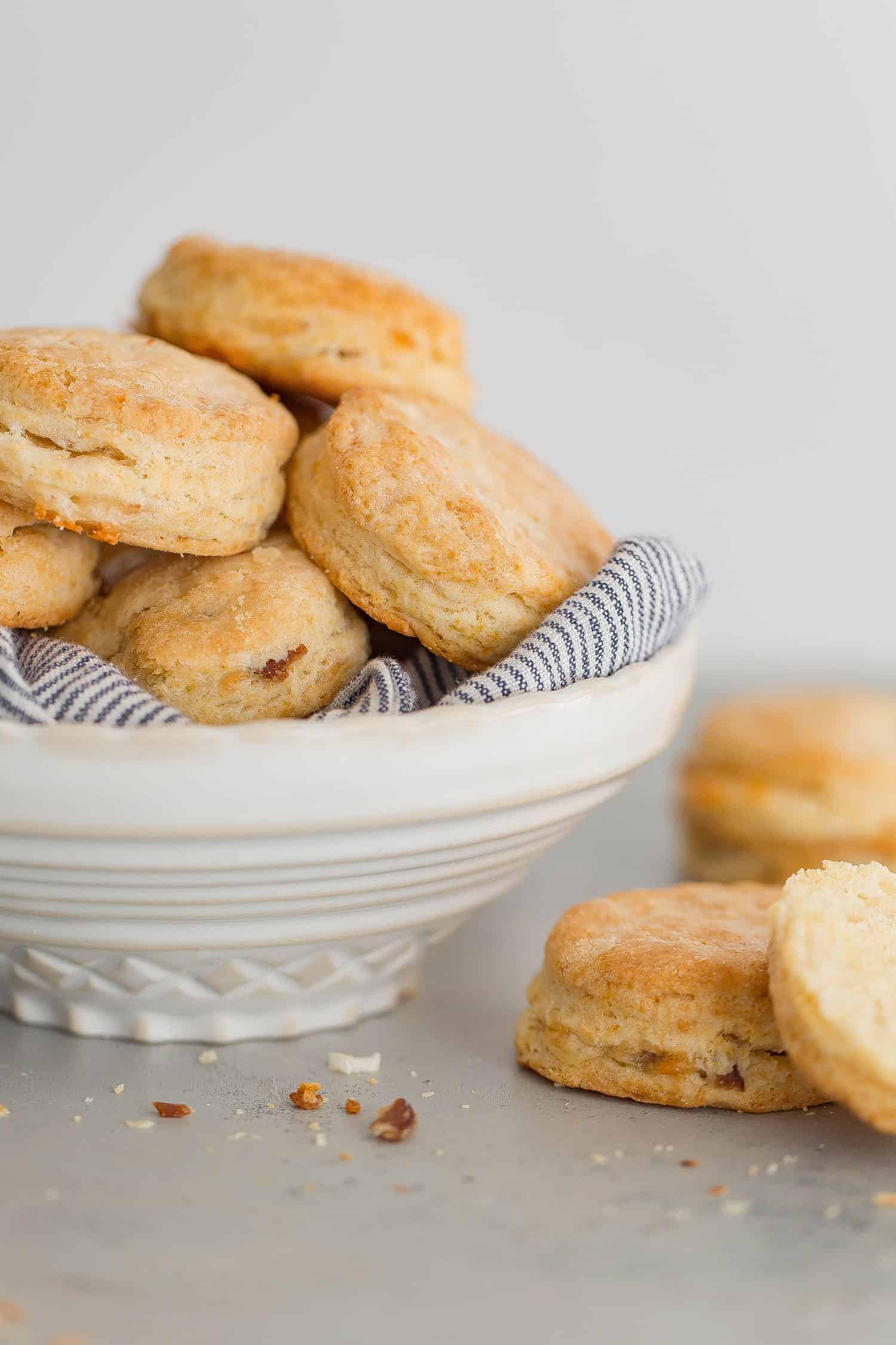 A large white bowl filled with Cheddar Biscuits overflowing ready to serve