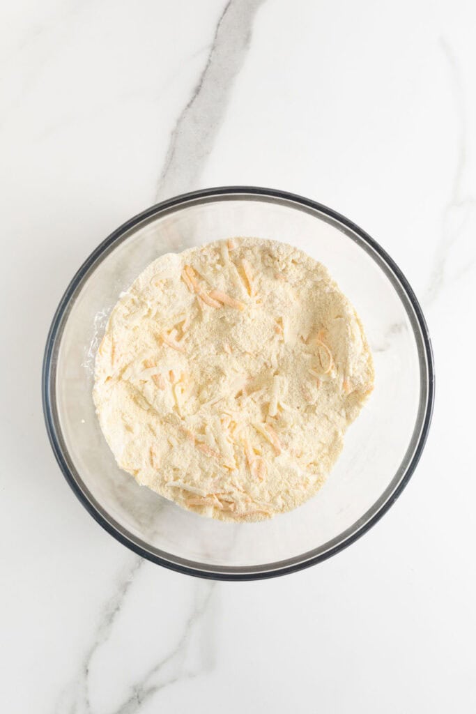 Mixed cheeses and dry ingredients in a glass bowl