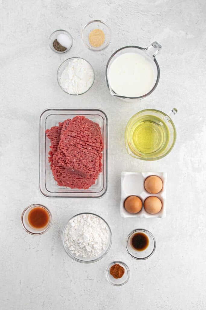 Ingredients to make a country fried steak in various bowls.