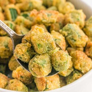 A close up of fried okra on a spoon before serving