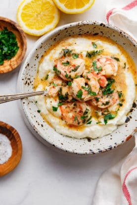 Overhead shot of Easy Shrimp Scampi and Grits in a white bowl with a spoon 