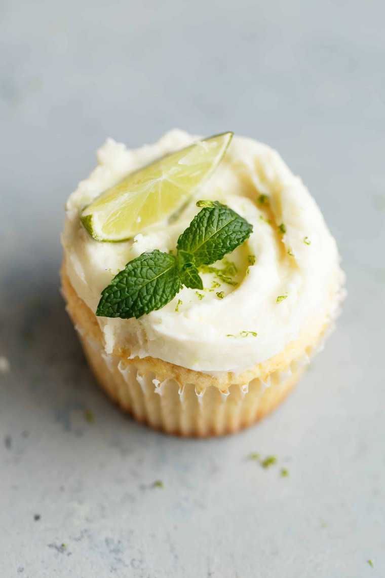 A delicious lemon cupcake with mojito buttercream against gray background