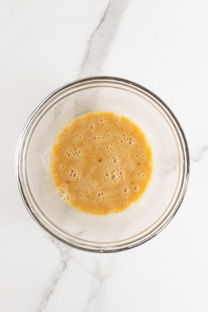 Eggs, hot sauce and worcestershire in a glass bowl whisked together
