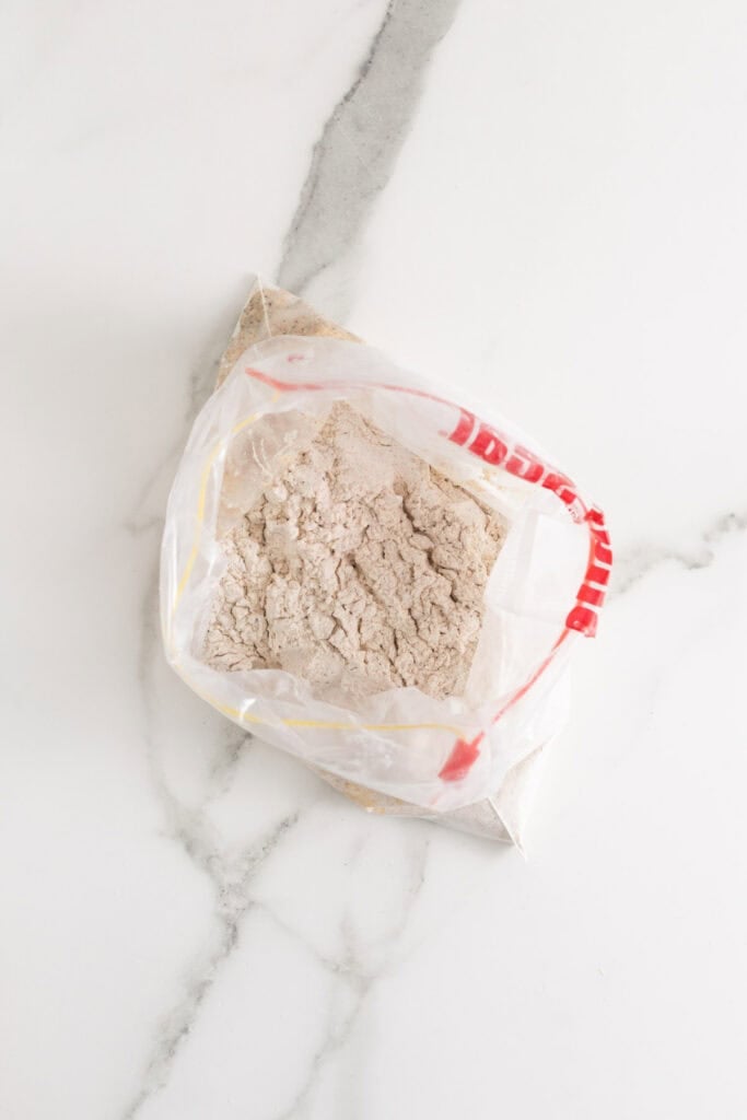 Drizzled milk in a seasoned flour in a bag