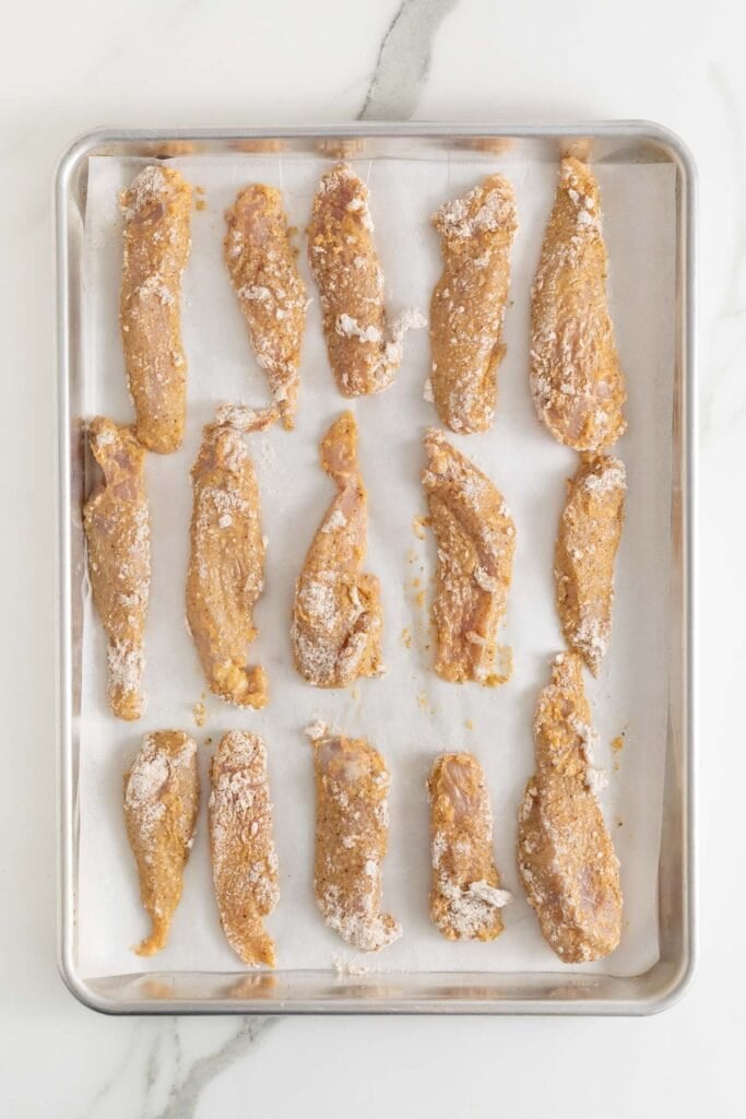 Chicken added to a baking sheet before baking