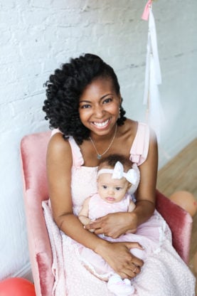 A seated Jocelyn smiling and holding Harmony