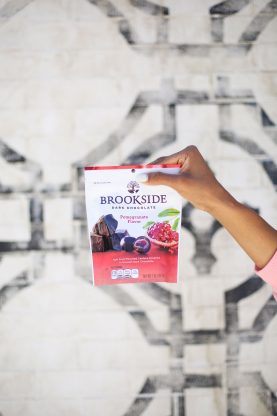 Brookside Chocolate pack being held against a brick wall