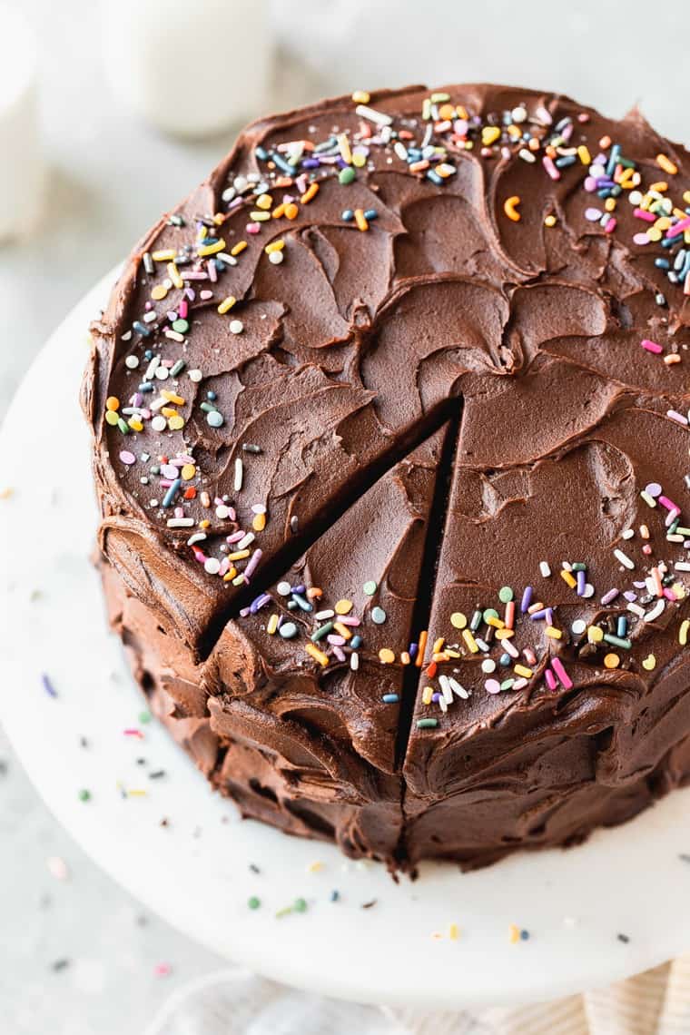 Overhead of best chocolate birthday cake recipe with sprinkles with a slice of cake