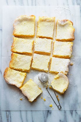 A delicious overhead shot of slices of ooey gooey butter cake with powdered sugar sprinkled on top