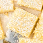 Slices of ooey gooey butter cake with powdered sugar overhead with a spatula serving one