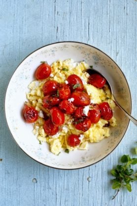 Overhead shot of a bowl of Goat Cheese Scrambled Eggs with a spoon in it