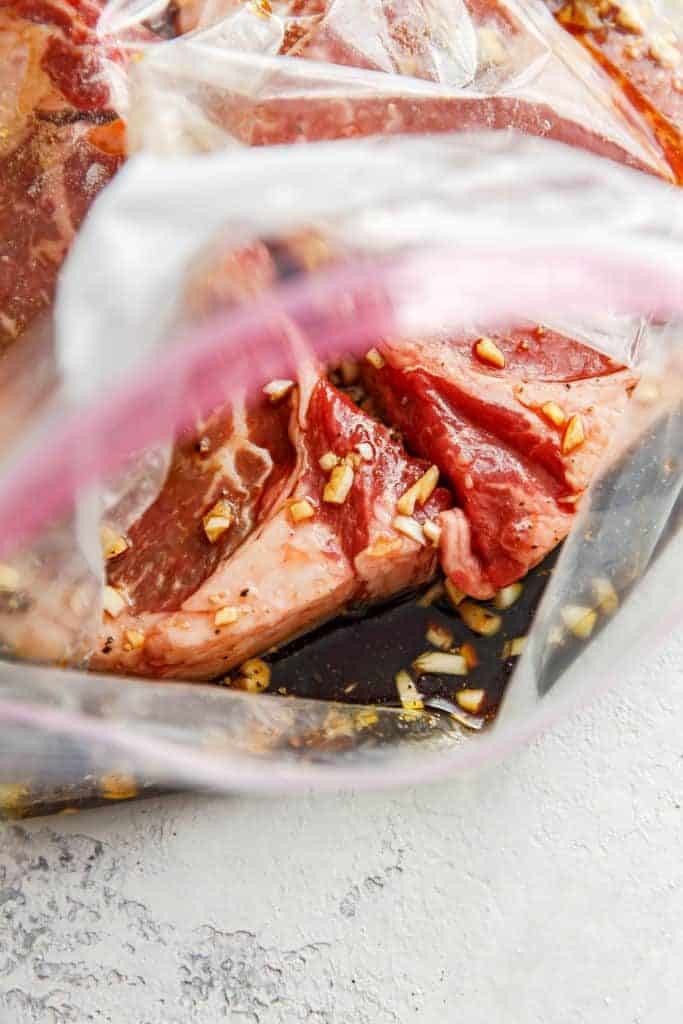 Ribeye steak in a plastic storage bag marinating