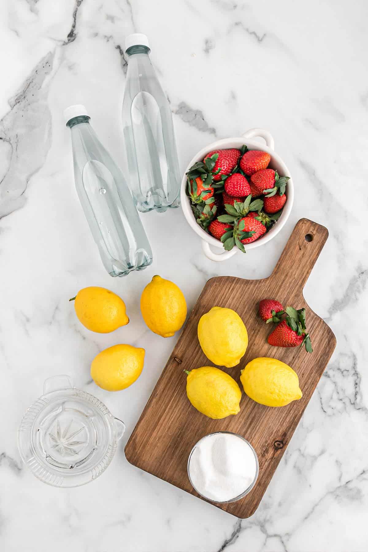 Ingredients to make homemade strawberry lemonade on the table.