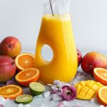 Mango fruit punch in a vessel surrounded by gorgeous fresh fruits